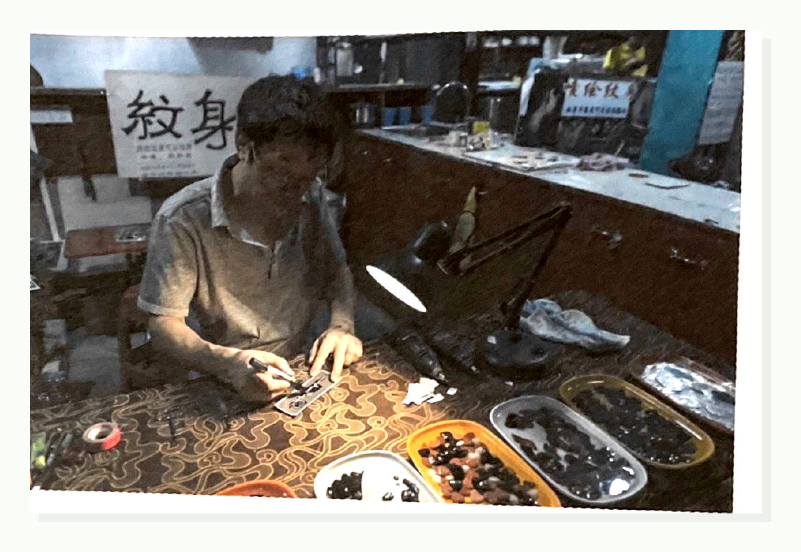 学生练习图片：一位年轻人在纹身店里纹身。